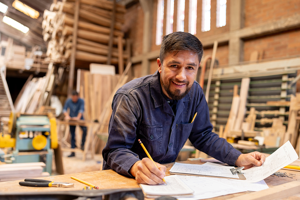 Junger Mann in der Werkstatt an seinem Arbeitstisch
